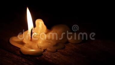 美丽的燃烧蜡烛，火焰从<strong>灯芯</strong>和蜡光进入黑暗的木桌背景与复制空间f。